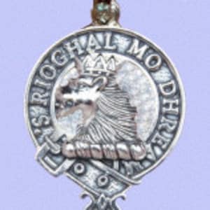 May include: Silver pendant necklace with a round silver charm featuring a heraldic crest with a lion's head and the text "Spriochal Modh Dhre", a Scottish clan crest.