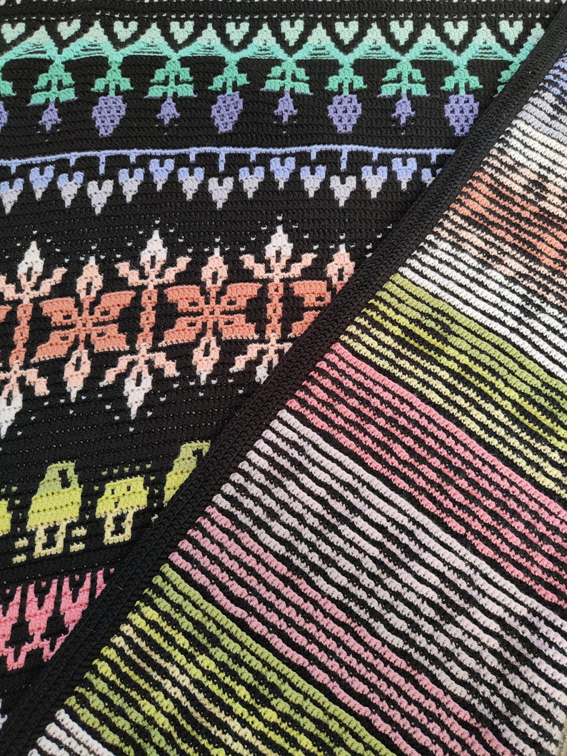 K&ouml;nnte beinhalten: Nahaufnahme von zwei geh&auml;kelten Decken, eine mit schwarzem Hintergrund und bunten geometrischen Mustern, die andere mit einem gestreiften Muster in Rosa-, Gr&uuml;n- und Wei&szlig;t&ouml;nen.