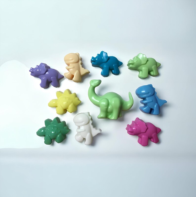 May include: A collection of ten colorful dinosaur-shaped figurines. The figurines are made of a smooth, pastel-colored material. The dinosaurs include a green stegosaurus, a purple triceratops, a yellow spinosaurus, a blue brachiosaurus, a green tyrannosaurus rex, a pink triceratops, a blue triceratops, a cream-colored tyrannosaurus rex, a white tyrannosaurus rex, and a light green brachiosaurus.
