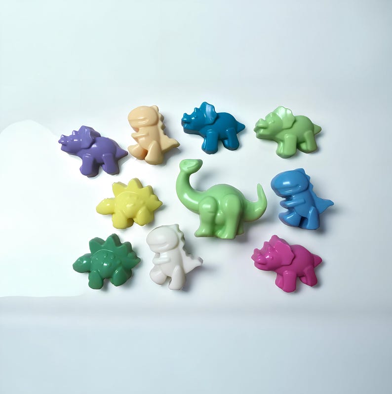 May include: A collection of ten colorful dinosaur-shaped figurines. The figurines are made of a smooth, pastel-colored material. The dinosaurs include a green stegosaurus, a purple triceratops, a yellow spinosaurus, a blue brachiosaurus, a green tyrannosaurus rex, a pink triceratops, a blue triceratops, a cream-colored tyrannosaurus rex, a white tyrannosaurus rex, and a light green brachiosaurus.