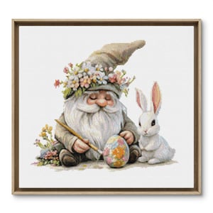 May include: A gnome with a flower crown is painting an Easter egg while a white rabbit sits beside him.