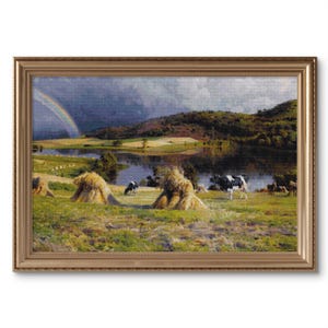 Può includere: Un dipinto che rappresenta un paesaggio rurale con un lago, mucche e un arcobaleno nel cielo. La scena è ambientata in un campo con balle di fieno sparse ovunque. Il cielo è nuvoloso e il lago riflette la luce del sole.