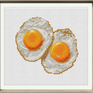 May include: Two fried eggs with bright yellow yolks, the whites are slightly browned and the edges are crispy.