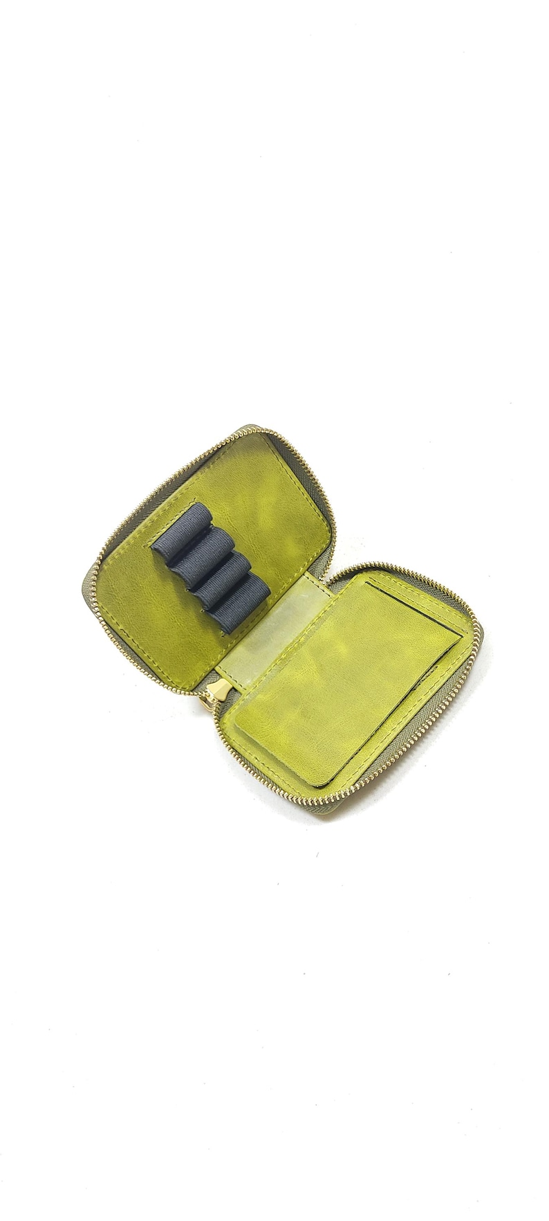 May include: Open, olive green leather pencil case with a zipper closure. The interior features a pen holder and a small pocket. The case is designed to hold pens, pencils, and other small stationery items.