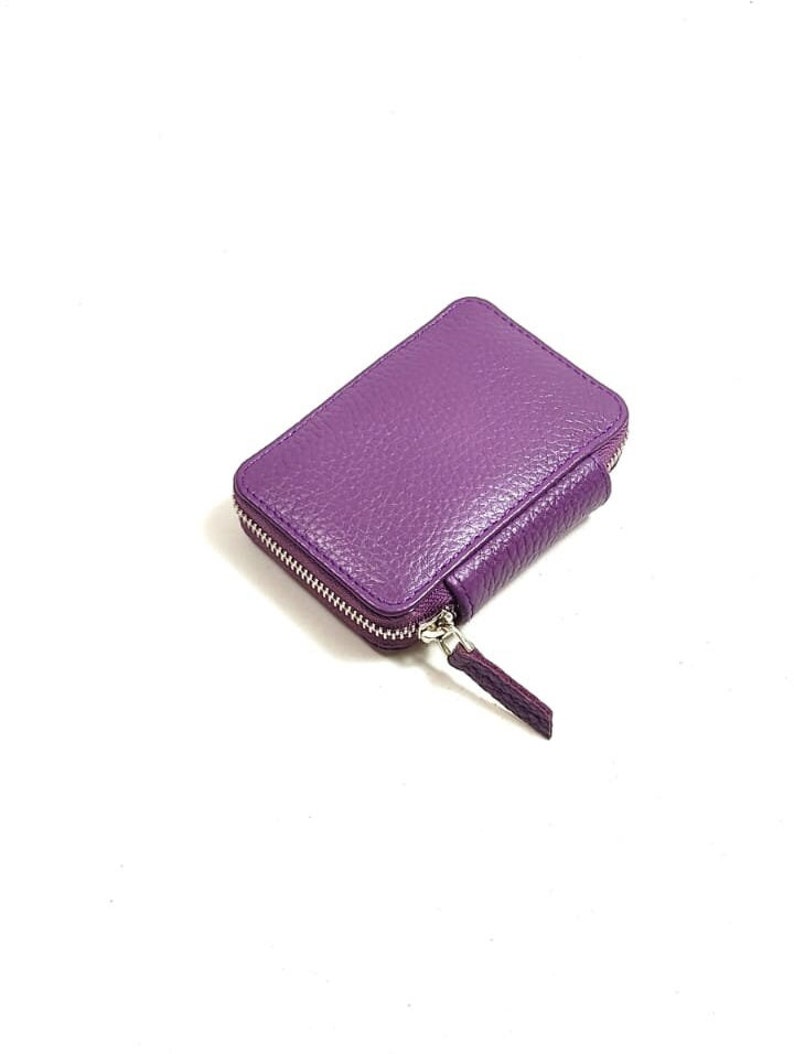 May include: A small purple leather zippered wallet.