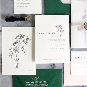 May include: Wedding invitation suite with green envelopes, white and cream cardstock, and a wax seal. The invitation features a floral illustration and the text "KIM and MIKE". The RSVP card includes the text "RSVP" and "kindly respond by the fifteenth of July".