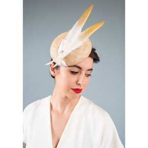 Goldie Beautiful Bridal Headpiece featuring gold tipped feathers and silk tie on a natural straw button base image 1