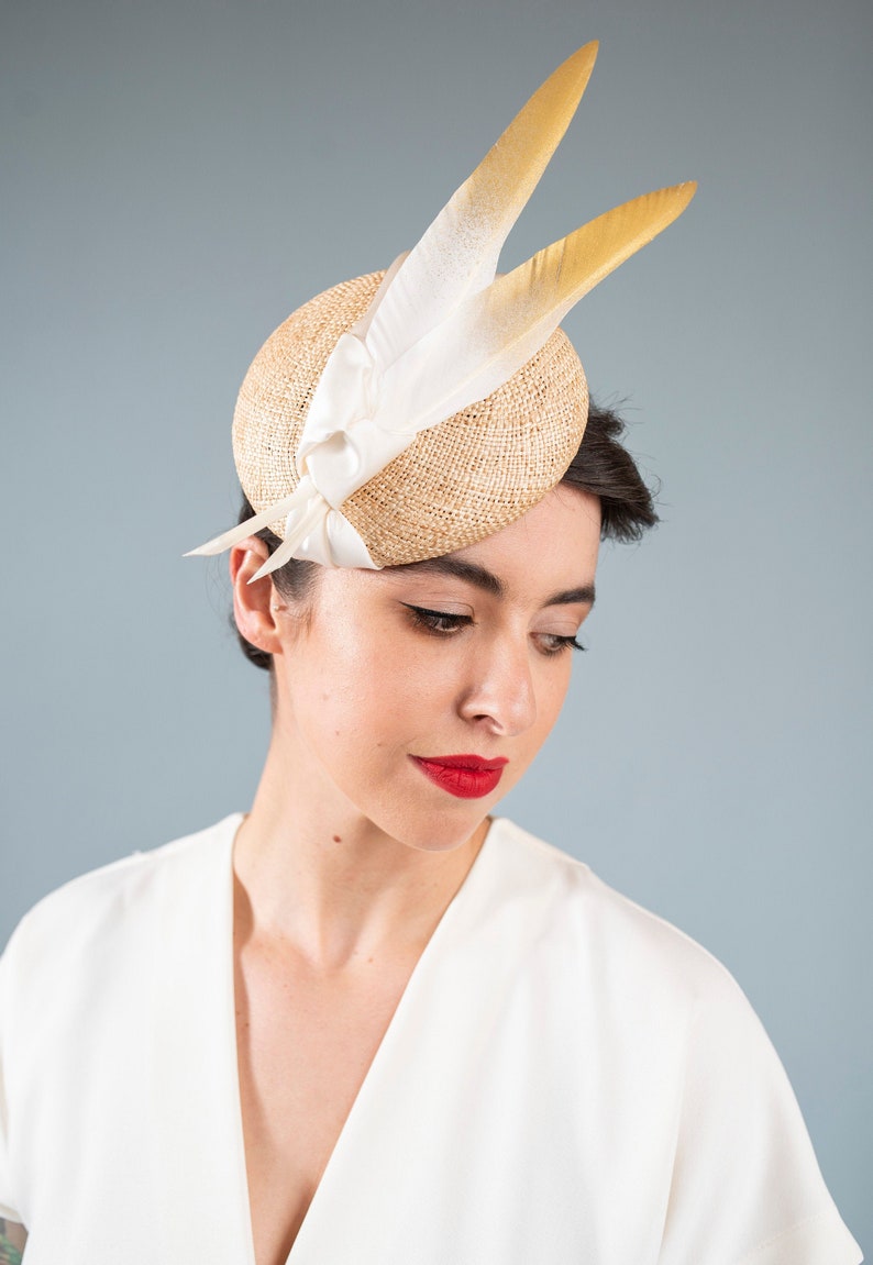 Goldie Beautiful Bridal Headpiece featuring gold tipped feathers and silk tie on a natural straw button base image 2
