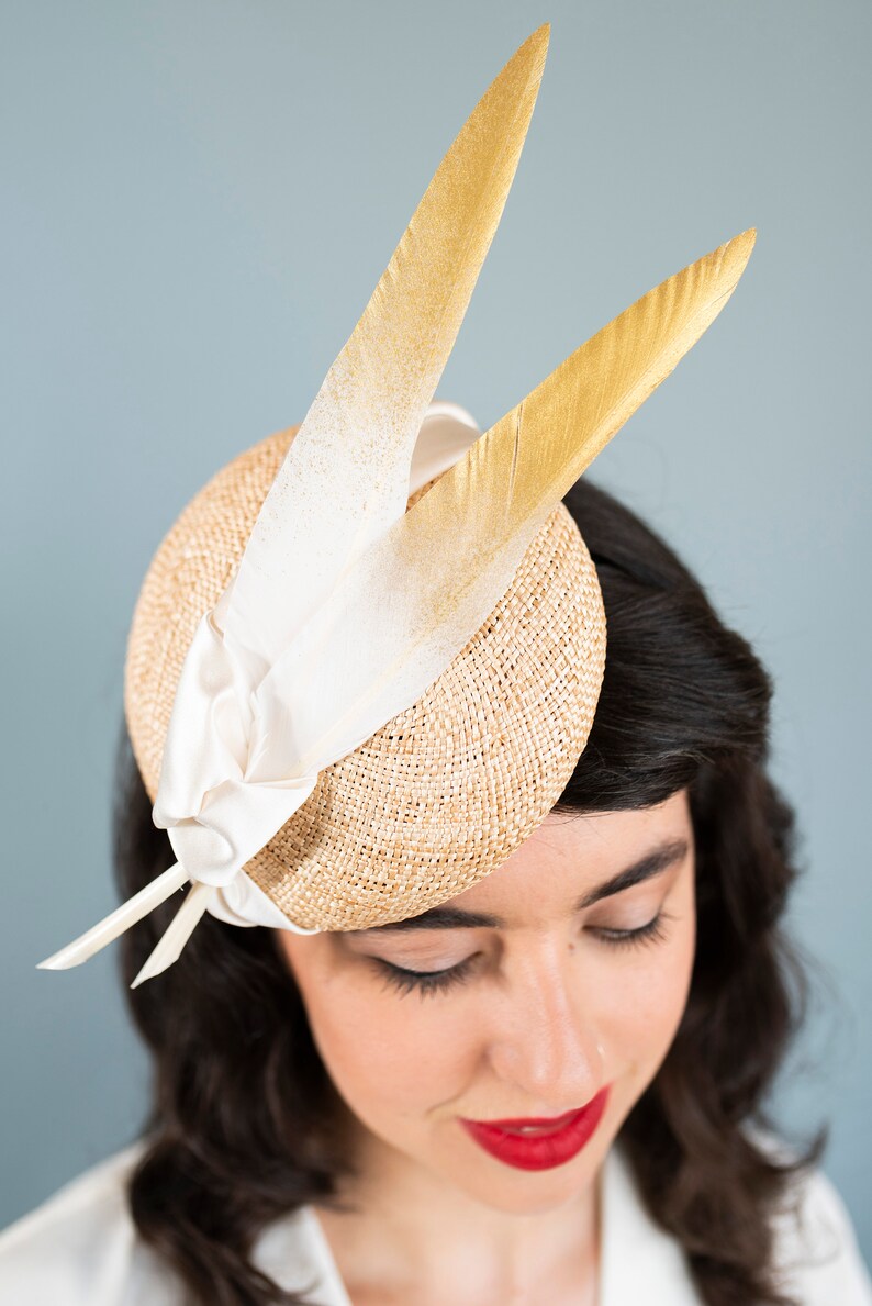 Goldie Beautiful Bridal Headpiece featuring gold tipped feathers and silk tie on a natural straw button base image 5