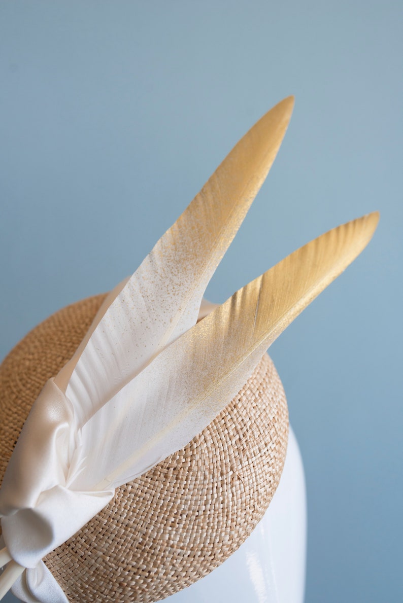 Goldie Beautiful Bridal Headpiece featuring gold tipped feathers and silk tie on a natural straw button base image 6