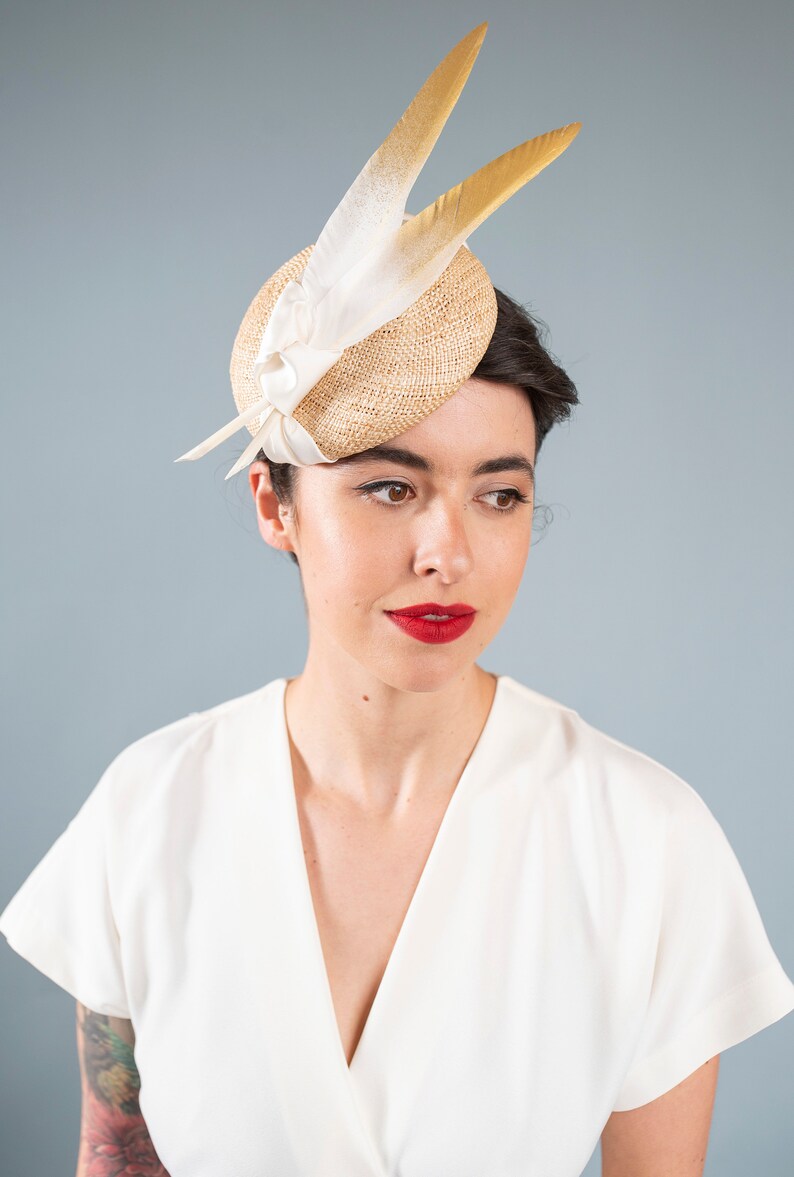 Goldie Beautiful Bridal Headpiece featuring gold tipped feathers and silk tie on a natural straw button base image 4