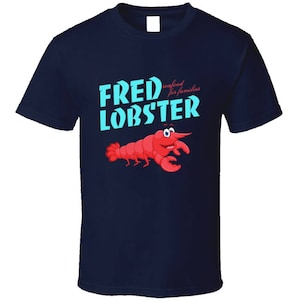 May include: Navy blue t-shirt with a cartoon lobster and the text "Fred Lobster - Seafood for families".