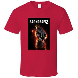 May include: A red t-shirt featuring a graphic from the movie "Backdraft 2." The graphic shows a firefighter in a dark jacket, surrounded by flames. The movie title is printed in white block letters above the image.