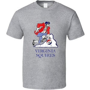 May include: A gray t-shirt with a vintage-style illustration of a cartoon basketball player dribbling a ball in front of the outline of the state of Virginia. The text "VIRGINIA SQUIRES" is printed below the illustration.