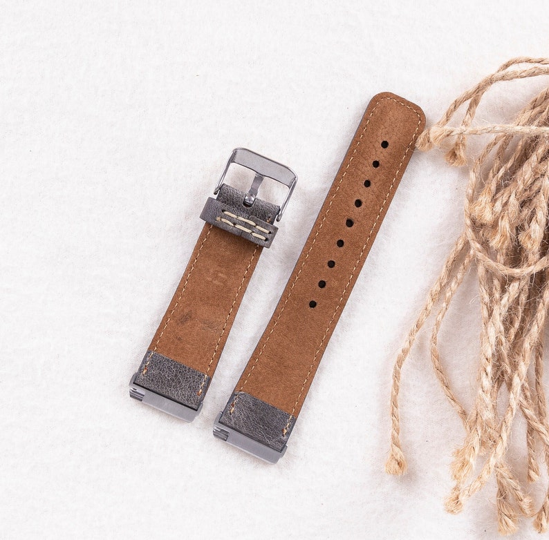 May include: Two brown leather watch bands with silver buckles. The bands have a distressed look and are stitched with white thread.