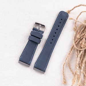 May include: Two blue leather watch straps with white stitching. The straps have silver buckles.