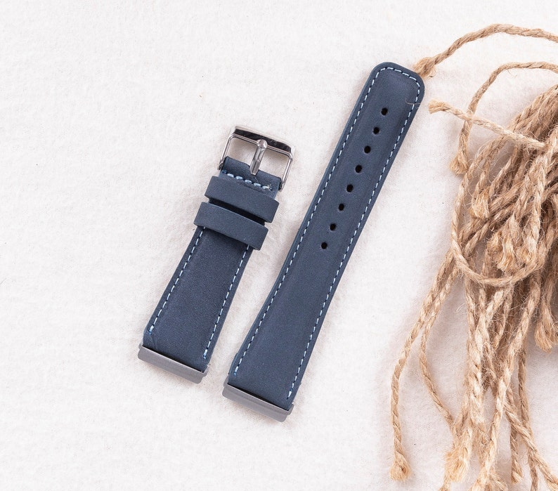 May include: Two blue leather watch straps with white stitching. The straps have silver buckles.