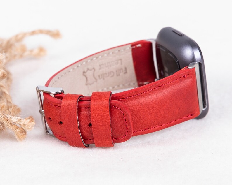 Puede incluir: Correa de reloj de cuero rojo con hebilla plateada y el texto "Full Grain Leather" en la parte posterior.