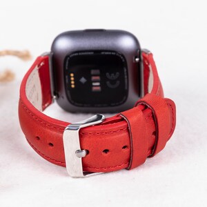 Puede incluir: Pulsera de reloj de cuero rojo con hebilla plateada. La pulsera est&aacute; dise&ntilde;ada para un reloj inteligente con una cara cuadrada.