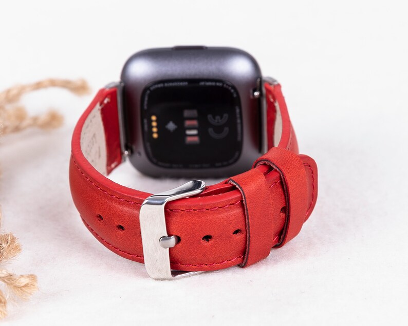 Puede incluir: Pulsera de reloj de cuero rojo con hebilla plateada. La pulsera est&aacute; dise&ntilde;ada para un reloj inteligente con una cara cuadrada.