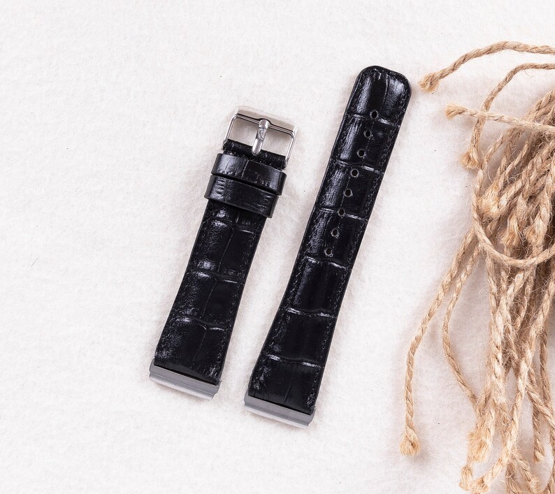 May include: Two black leather watch straps with silver buckles. The straps have a crocodile pattern.