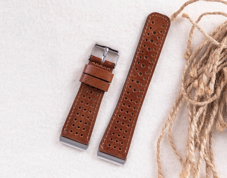 May include: Two brown leather watch straps with a perforated design. The straps have silver buckles.