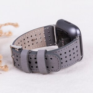 Puede incluir: Correa de reloj de cuero gris con un dise&ntilde;o perforado. La correa es compatible con relojes inteligentes con una anchura de leng&uuml;eta est&aacute;ndar de 20 mm.