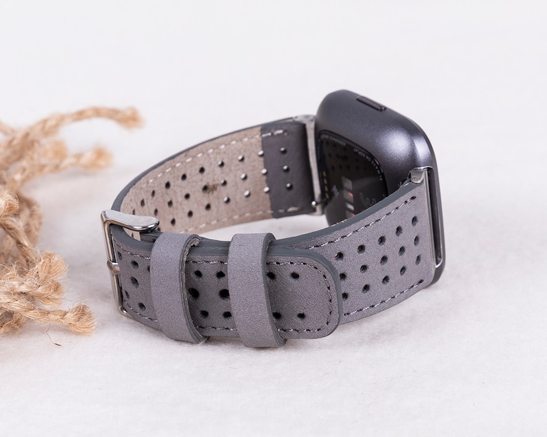 Puede incluir: Correa de reloj de cuero gris con un dise&ntilde;o perforado. La correa es compatible con relojes inteligentes con una anchura de leng&uuml;eta est&aacute;ndar de 20 mm.