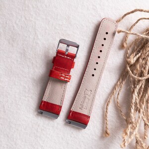 Puede incluir: Dos correas de reloj de cuero rojo con costuras blancas. La correa de la derecha tiene el texto "Full Grain Leather" grabado.