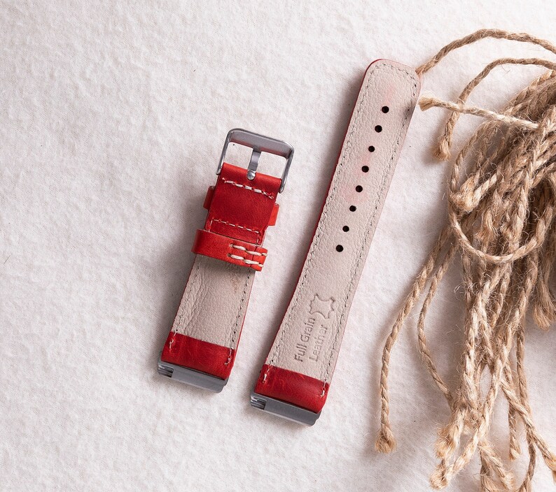 Puede incluir: Dos correas de reloj de cuero rojo con costuras blancas. La correa de la derecha tiene el texto "Full Grain Leather" grabado.