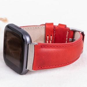Puede incluir: Pulsera de reloj de cuero rojo con hebilla plateada. La pulsera est&aacute; dise&ntilde;ada para un reloj inteligente con una cara cuadrada.