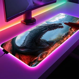 May include: A black and red gaming mouse pad with a dragon and a woman in a red dress. The mouse pad has a bright pink LED light around the edge.