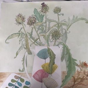 Karczochy w dzbanku w kształcie zegara dmuchawcowego firmy Sandersons o wymiarach 48 cm x 48 cm