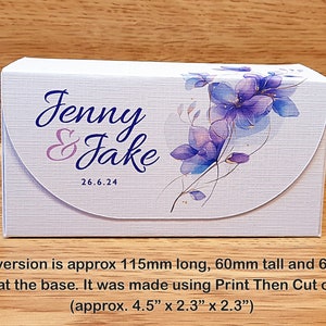 May include: A white box with a floral design and the text "Jenny & Jake 26.6.24". The box is approximately 4.5 inches long, 2.3 inches tall, and 2.3 inches deep.