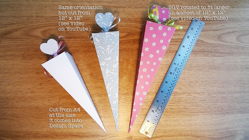 May include: Three paper cones with different patterns and colors. The cones are decorated with hearts and ribbons. The cones are 12 inches tall and are made from 12 inch by 12 inch paper. The cones are cut from A4 paper.