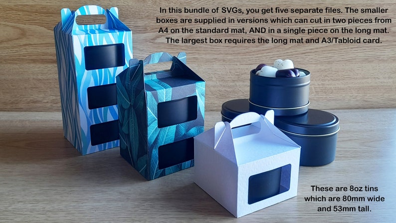 May include: Five different box designs for 8 oz tins. The boxes are made of cardboard and have a window to show the tin inside. The boxes are decorated with different patterns, including blue and white stripes, green leaves, and white. The tins are black and have a gold rim. The text on the image reads "These are 8oz tins which are 80mm wide and 53mm tall."