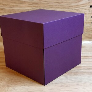 May include: A purple square explosion box. This box is made of sturdy cardboard and can be used for a variety of purposes.
