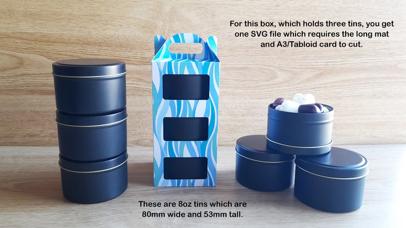 May include: A set of three black metal tins with a blue and white patterned box. The tins are 8 ounces each and measure 80mm wide and 53mm tall. The box has three cut-out windows to display the tins.  "For this box, which holds three tins, you get one SVG file which requires the long mat and A3/Tabloid card to cut. These are 8oz tins which are 80mm wide and 53mm tall."