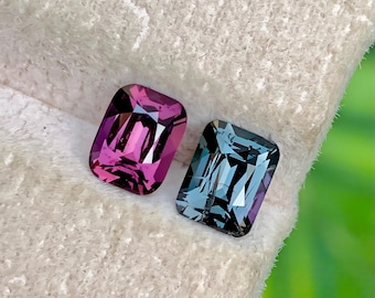 Può includere: Due pietre preziose rettangolari. Una è di colore magenta intenso, l'altra blu-verde. Entrambe hanno un taglio sfaccettato che riflette la luce. Le gemme sono su uno sfondo bianco strutturato.