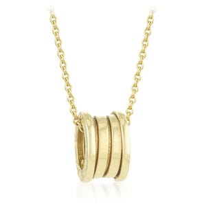 May include: A gold-colored necklace featuring a pendant with a cylindrical design composed of four stacked, rounded bands. The necklace chain and pendant are a matching gold tone, creating a cohesive and elegant look. The pendant is centered on the chain.
