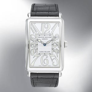 May include: A rectangular silver wristwatch with a white face and black leather strap. The watch face displays large, stylized numerals and the text "FRANCK MULLER GENEVE LONG ISLAND". The watch has a small crown and a black leather strap.