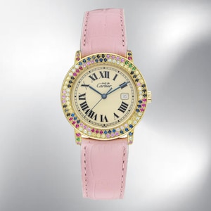 May include: A gold-toned wristwatch with a cream-colored face, black Roman numerals, and the text "mut de Cartier". The bezel is adorned with colorful gemstones. It has a pink leather strap.