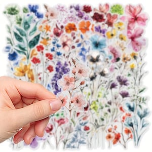 Könnte beinhalten: Eine Sammlung farbenfroher Blumenaufkleber mit einer Vielzahl von Blumen in Rosa, Blau, Gelb und Lila. Eine Hand hält einen Aufkleber mit rosa Blüten. Die Aufkleber eignen sich ideal zum Scrapbooking, Journaling oder Dekorieren.