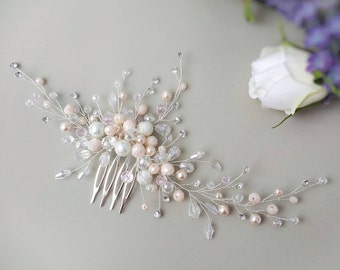 May include: A silver hair comb with a delicate design featuring pink and white pearls and crystals. The comb is perfect for adding a touch of sparkle to any hairstyle.