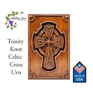 May include: A wooden urn with a carved Celtic cross design. The cross is a Trinity Knot, a traditional Celtic symbol. The urn is made in the USA.