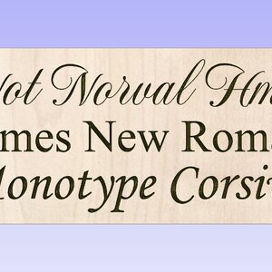May include: A close-up of a wooden sign with the text "Not Normal Hmk" in a cursive font. The text "Times New Roman" and "Monotype Corsiva" are also visible below the first line of text.