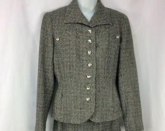 May include: A tweed skirt suit with a jacket and skirt. The jacket has a notched collar, gold buttons, and two decorative pockets. The tweed fabric is a mix of black, green, and red threads. The skirt is a matching pencil skirt.