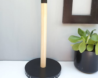 May include: Black and wood paper towel holder with a black base and white polka dots around the edge.