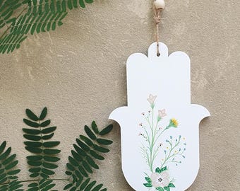 Pode incluir: Decoração de parede de madeira branca em forma de mão com um design floral. O design apresenta flores rosa e brancas, folhas verdes e detalhes amarelos.