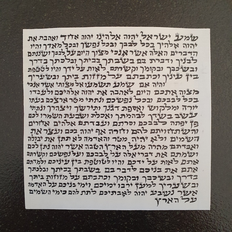 May include: A black and white image of a Hebrew text on a white paper background. The text is written in a traditional Hebrew script and includes the words "Shema Yisrael" and "Adonai Eloheinu Adonai Echad".